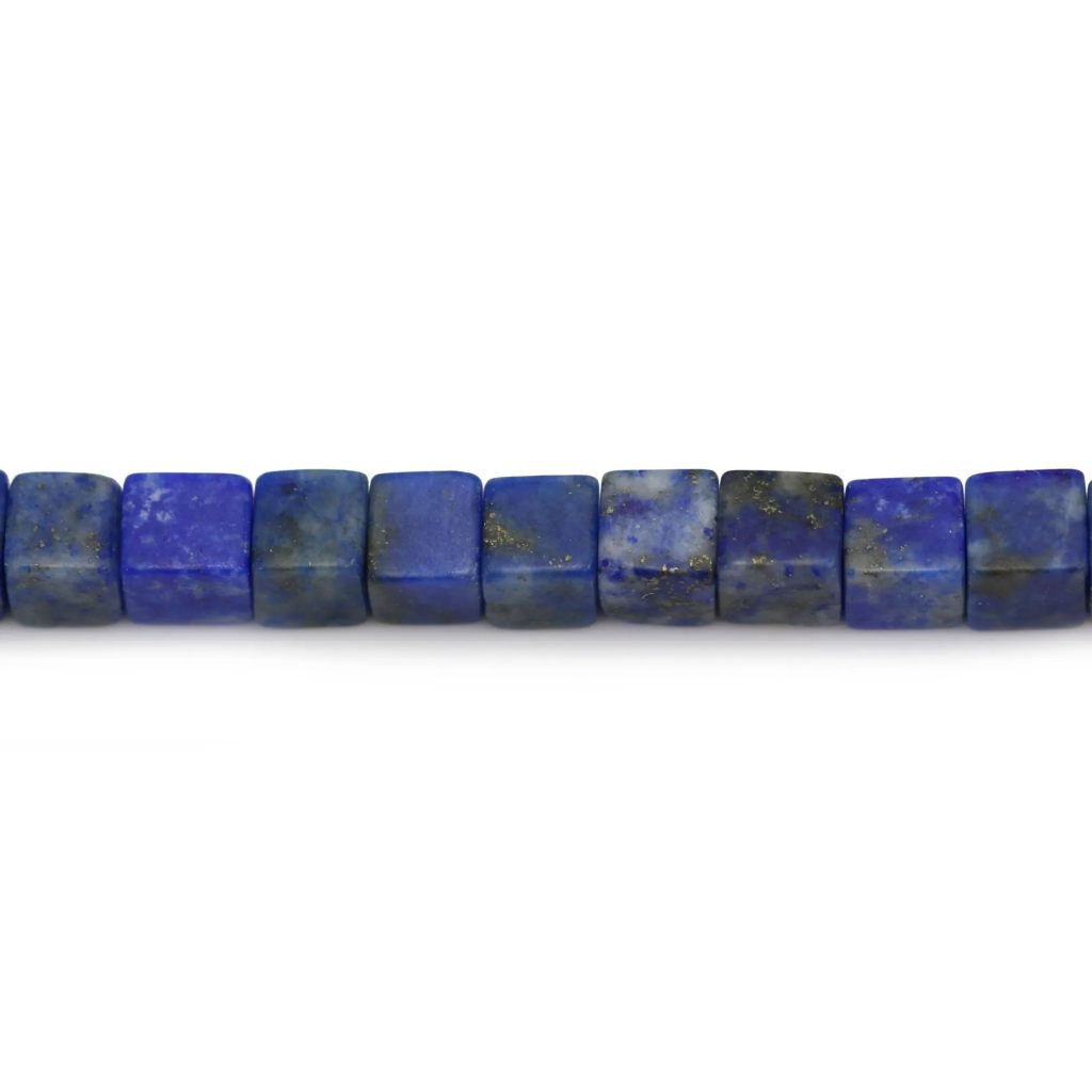 A horizontal string of square-cut deep blue lapis lazuli beads with natural golden pyrite flecks and grey mottling